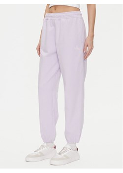 Calvin Klein Jeans Spodnie dresowe Monologo LV047B235G Fioletowy Regular Fit ze sklepu MODIVO w kategorii Spodnie damskie - zdjęcie 183706231
