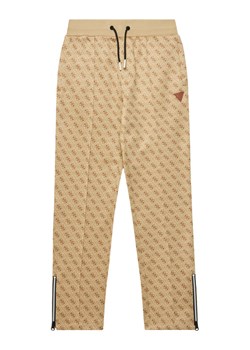 Guess Spodnie dresowe L4YQ18 FL04Q Beżowy Regular Fit ze sklepu MODIVO w kategorii Spodnie chłopięce - zdjęcie 183814044