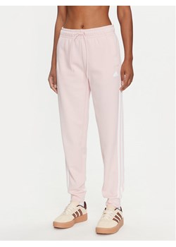 adidas Spodnie dresowe Future Icons 3-Stripes IW5194 Różowy Regular Fit ze sklepu MODIVO w kategorii Spodnie damskie - zdjęcie 183945182