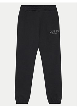 Guess Spodnie dresowe L4BQ15 KAV33 Czarny Regular Fit ze sklepu MODIVO w kategorii Spodnie chłopięce - zdjęcie 183985830