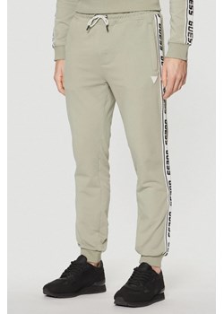 GUESS Zielone męskie spodnie dresowe z lampasami New Arlo, Rozmiar S ze sklepu outfit.pl w kategorii Spodnie męskie - zdjęcie 184012554