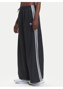 adidas Spodnie dresowe adicolor Firebird JD3390 Czarny Loose Fit ze sklepu MODIVO w kategorii Spodnie damskie - zdjęcie 184019372