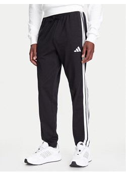 adidas Spodnie dresowe Essentials 3-Stripes JE6430 Czarny Regular Fit ze sklepu MODIVO w kategorii Spodnie męskie - zdjęcie 184019391
