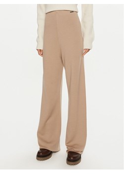 Calvin Klein Spodnie dresowe K20K207680 Beżowy Relaxed Fit ze sklepu MODIVO w kategorii Spodnie damskie - zdjęcie 184058061