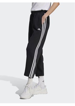 adidas Spodnie dresowe Essentials 3-Stripes Open Hem Fleece HZ5748 Czarny Loose Fit ze sklepu MODIVO w kategorii Spodnie damskie - zdjęcie 184098252