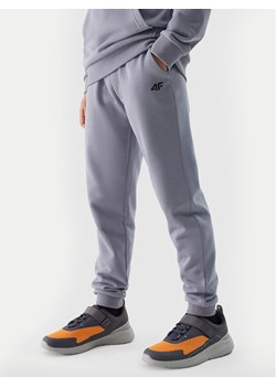 4F Spodnie dresowe 4FJWSS24TTROM591 Niebieski Regular Fit ze sklepu MODIVO w kategorii Spodnie chłopięce - zdjęcie 184105513