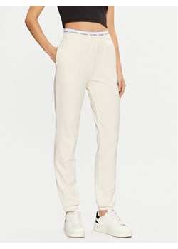 Guess Spodnie dresowe O5RB01 KCO31 Écru Regular Fit ze sklepu MODIVO w kategorii Spodnie damskie - zdjęcie 184187371