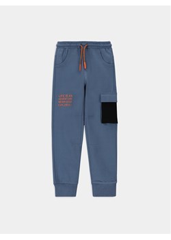Coccodrillo Spodnie dresowe WC4120102DEK Niebieski Slim Fit ze sklepu MODIVO w kategorii Spodnie chłopięce - zdjęcie 184214463