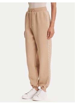 Guess Spodnie dresowe V5YB02 KB3P2 Beżowy Regular Fit ze sklepu MODIVO w kategorii Spodnie damskie - zdjęcie 184538752