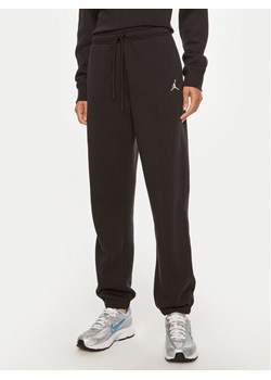 Nike Spodnie dresowe Brooklyn FN4494 Czarny Regular Fit ze sklepu MODIVO w kategorii Spodnie damskie - zdjęcie 184560672