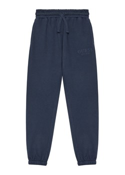 Guess Spodnie dresowe L5YQ19 KAV34 Granatowy Regular Fit ze sklepu MODIVO w kategorii Spodnie chłopięce - zdjęcie 184575400
