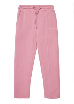 Guess Spodnie dresowe J5YQ17 KAV34 Różowy Regular Fit ze sklepu MODIVO w kategorii Spodnie dziewczęce - zdjęcie 184790320