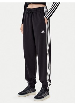 adidas Spodnie dresowe Essentials 3-Stripes Fleece JE1276 Czarny Loose Fit ze sklepu MODIVO w kategorii Spodnie damskie - zdjęcie 184920250