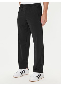 adidas Spodnie dresowe adicolor Classics Firebird JY1350 Czarny Regular Fit ze sklepu MODIVO w kategorii Spodnie męskie - zdjęcie 185040772