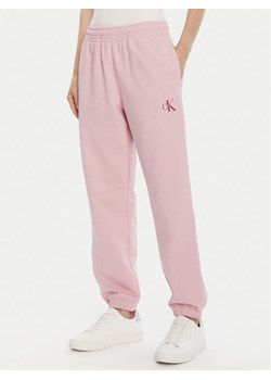 Calvin Klein Jeans Spodnie dresowe Moologo LV047B235G Różowy Regular Fit ze sklepu MODIVO w kategorii Spodnie damskie - zdjęcie 185466332