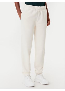 Lacoste Spodnie dresowe XF0353 Beżowy Regular Fit ze sklepu MODIVO w kategorii Spodnie damskie - zdjęcie 185634852