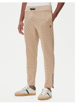 Guess Spodnie dresowe Z2BB05 K7122 Beżowy Regular Fit ze sklepu MODIVO w kategorii Spodnie męskie - zdjęcie 185634954