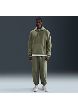 Męskie spodnie z dzianiny ze ściągaczami Nike Solo Swoosh - Zieleń ze sklepu Nike poland w kategorii Spodnie męskie - zdjęcie 185795632