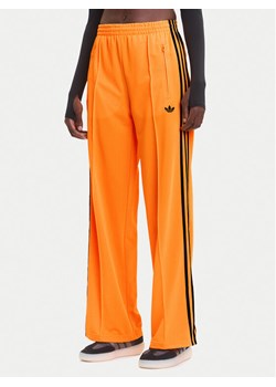 adidas Spodnie dresowe adicolor Classic Firebird JY2694 Żółty Loose Fit ze sklepu MODIVO w kategorii Spodnie damskie - zdjęcie 185913110