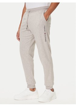 Tommy Hilfiger Spodnie dresowe UM0UM03664 Beżowy Regular Fit ze sklepu MODIVO w kategorii Spodnie męskie - zdjęcie 186028581