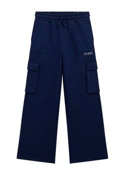 Guess Spodnie dresowe J5BQ13 KCKF2 Granatowy Relaxed Fit ze sklepu MODIVO w kategorii Spodnie chłopięce - zdjęcie 186294813