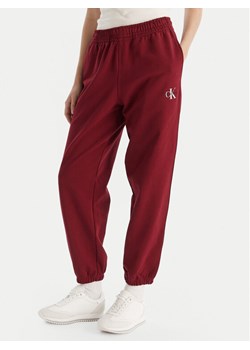 Calvin Klein Jeans Spodnie dresowe Monologo LV047B235G Bordowy Regular Fit ze sklepu MODIVO w kategorii Spodnie damskie - zdjęcie 186379132