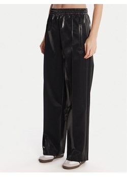 adidas Spodnie dresowe adicolor Holiday JV7503 Czarny Loose Fit ze sklepu MODIVO w kategorii Spodnie damskie - zdjęcie 186806373