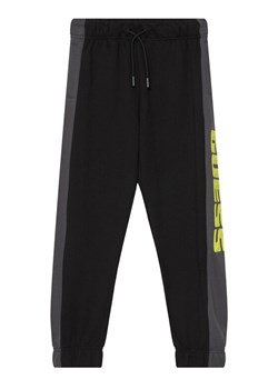 Guess Spodnie dresowe L6RB01 KA6R4 Czarny Regular Fit ze sklepu MODIVO w kategorii Spodnie chłopięce - zdjęcie 187664970