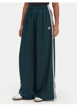 adidas Spodnie dresowe adicolor Satin JV7511 Zielony Wide Leg ze sklepu MODIVO w kategorii Spodnie damskie - zdjęcie 187673252
