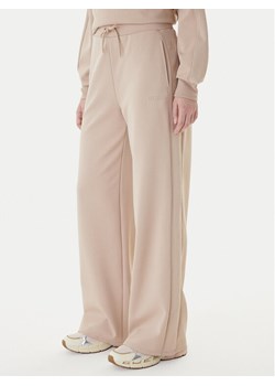 Guess Spodnie dresowe V5BB12 KCX22 Beżowy Regular Fit ze sklepu MODIVO w kategorii Spodnie damskie - zdjęcie 187681044