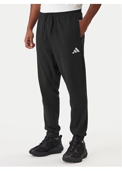 adidas Spodnie dresowe Essentials Feel Cozy JE3854 Czarny Regular Fit ze sklepu MODIVO w kategorii Spodnie męskie - zdjęcie 187803112
