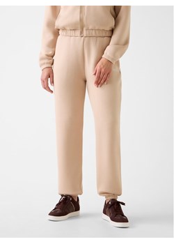 Guess Spodnie materiałowe 169841 Beżowy Slim Fit ze sklepu MODIVO w kategorii Spodnie damskie - zdjęcie 187851694