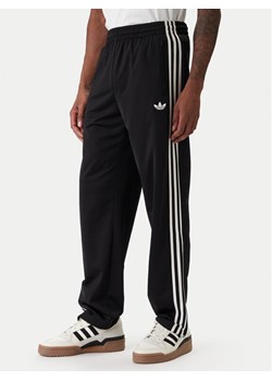 adidas Spodnie dresowe Firebird KD8315 Czarny Loose Fit ze sklepu MODIVO w kategorii Spodnie męskie - zdjęcie 187851784