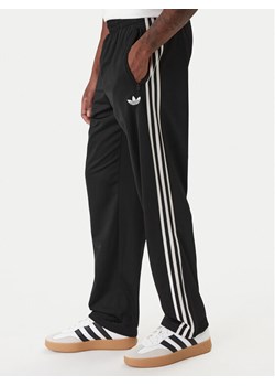 adidas Spodnie dresowe Firebird KD8315 Czarny Loose Fit ze sklepu MODIVO w kategorii Spodnie męskie - zdjęcie 187853013