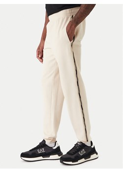 EA7 Emporio Armani Spodnie dresowe 7M001482 AF12660 U1088 Beżowy Regular Fit ze sklepu MODIVO w kategorii Spodnie męskie - zdjęcie 187934142