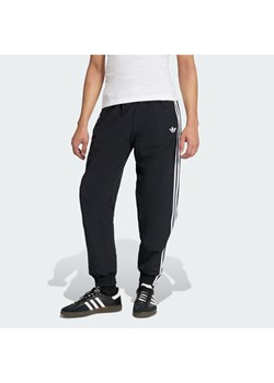 adidas Spodnie dresowe Firebird Woven KE1371 Czarny Regular Fit ze sklepu MODIVO w kategorii Spodnie męskie - zdjęcie 187934154