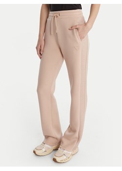 Guess Spodnie dresowe V3RB21 K7UW2 Beżowy Regular Fit ze sklepu MODIVO w kategorii Spodnie damskie - zdjęcie 187964460