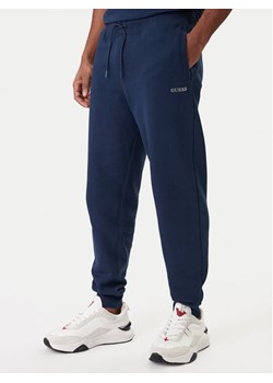Guess Spodnie dresowe Z6RB12 KAIJ1 Granatowy Regular Fit ze sklepu MODIVO w kategorii Spodnie męskie - zdjęcie 188007764