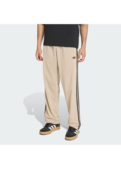 adidas Spodnie dresowe Firebird KE6679 Beżowy Loose Fit ze sklepu MODIVO w kategorii Spodnie męskie - zdjęcie 188013343
