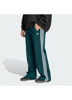 adidas Spodnie dresowe Firebird KG3701 Zielony Loose Fit ze sklepu MODIVO w kategorii Spodnie damskie - zdjęcie 188027912