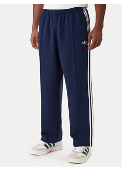 adidas Spodnie dresowe adicolor Spacer Track KD4087 Granatowy Baggy Fit ze sklepu MODIVO w kategorii Spodnie męskie - zdjęcie 188039100