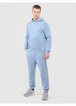 Męskie spodnie dresowe Outhorn OTHWAW24TTROM1220 - niebieskie ze sklepu Sportstylestory.com w kategorii Spodnie męskie - zdjęcie 188068912