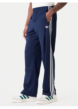 adidas Spodnie dresowe Firebird KD8316 Granatowy Loose Fit ze sklepu MODIVO w kategorii Spodnie męskie - zdjęcie 188070484