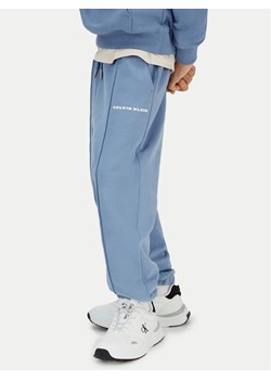 Calvin Klein Jeans Spodnie dresowe Pintuck IB0IB02605 Niebieski Relaxed Fit ze sklepu MODIVO w kategorii Spodnie dziewczęce - zdjęcie 188074863
