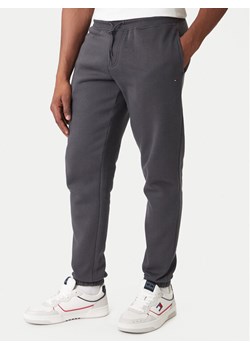 Tommy Jeans Spodnie dresowe DM0DM20473 Szary Regular Fit ze sklepu MODIVO w kategorii Spodnie męskie - zdjęcie 188075000