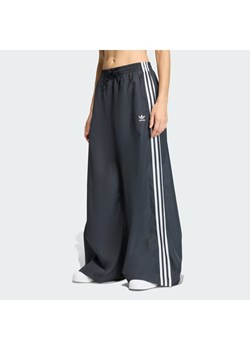 adidas Spodnie dresowe Firebird Adilenium KD2914 Czarny Regular Fit ze sklepu MODIVO w kategorii Spodnie damskie - zdjęcie 188083460