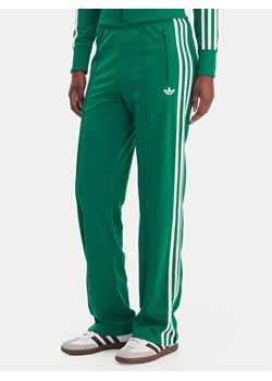 adidas Spodnie dresowe Firebird Classic KD3649 Zielony Regular Fit ze sklepu MODIVO w kategorii Spodnie damskie - zdjęcie 188112344