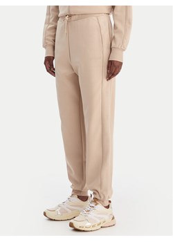 Guess Spodnie dresowe V5BB23 KCX22 Beżowy Regular Fit ze sklepu MODIVO w kategorii Spodnie damskie - zdjęcie 188118403