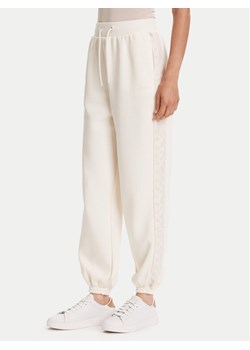 Guess Spodnie dresowe V5YB02 KB3P2 Écru Regular Fit ze sklepu MODIVO w kategorii Spodnie damskie - zdjęcie 188406683