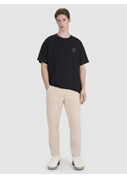 Męskie spodnie dresowe 4F 4FRSS25TTROM1447 - beżowe ze sklepu Sportstylestory.com w kategorii Spodnie męskie - zdjęcie 188509241